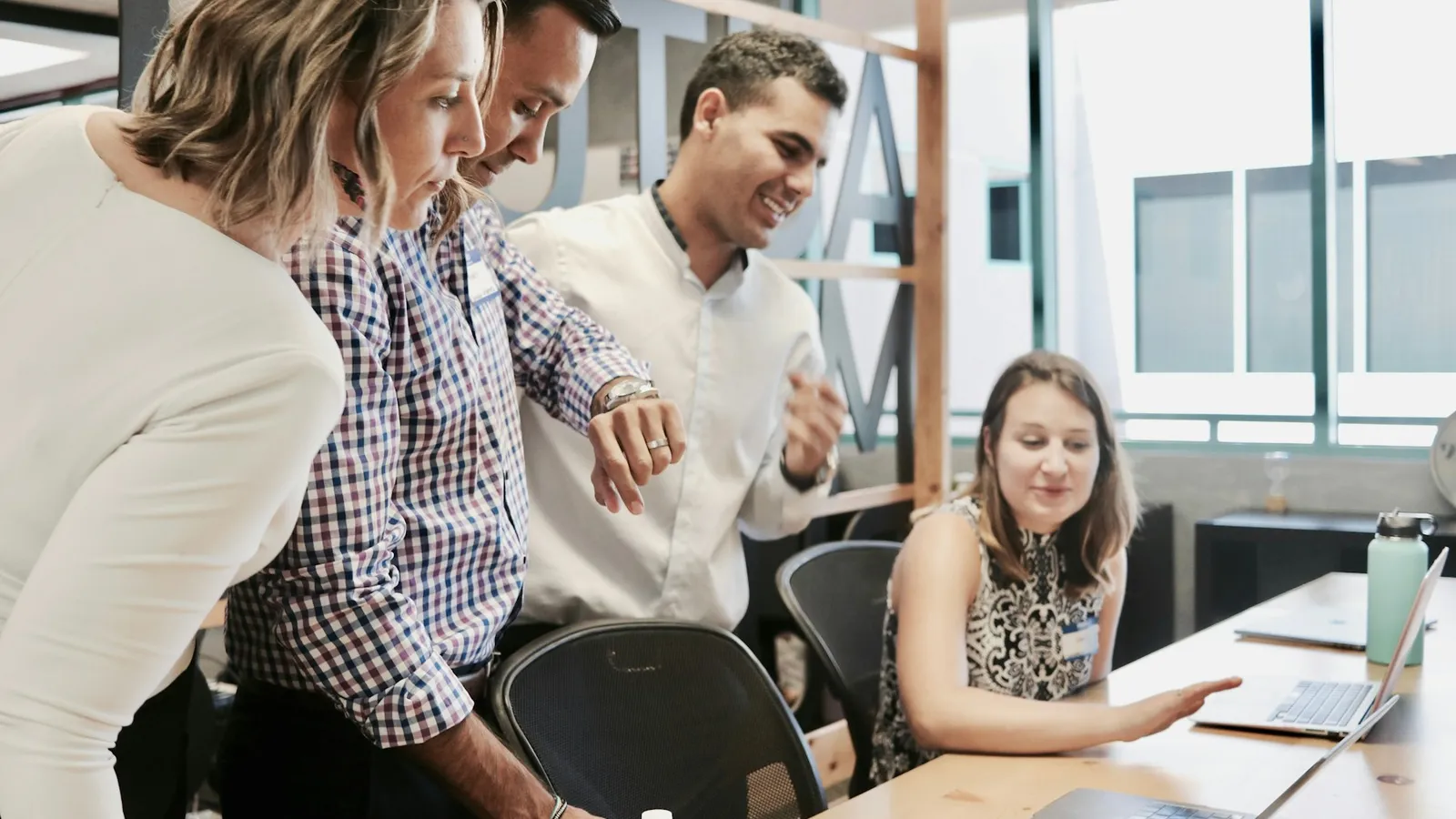 Real estate agents collaborating around a laptop on leads handed over by an AI agent