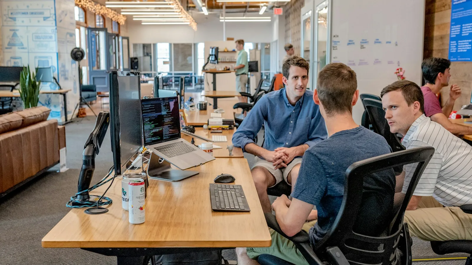 Growing real estate team working at shared desks with a common CRM
